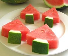 slices of watermelon are arranged on a white plate with green and red squares