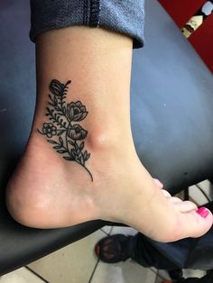 a woman's foot with a flower tattoo on it