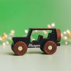 a wooden toy car with the word harper on it's side and lights in the background