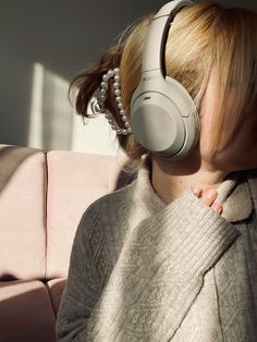 a woman wearing headphones sitting on a couch