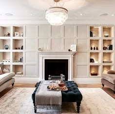 a living room filled with furniture and a fire place in front of a book shelf