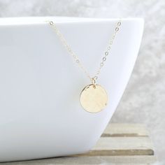 "Give her the MOON! The peacefulness of the moon is captured in this hammered gold disc necklace, and it is the perfect addition to your collection. And the perfect gift for the woman who has everything. She will NEVER take it off! Gorgeous rich 1/2\" (13mm) 14k gold fill disc is lightly hammered to create a unique textured look... every single one will be slightly different. This hangs from a 1.6mm gold filled cable chain to complete the look. It can be worn alone, or layered with other pieces Hammered Coin Necklace As Gift, Hammered Round Disc Coin Necklace As Gift, Hammered Coin Necklace Gift, Hammered Moon-shaped Jewelry For Gifts, Hammered Moon-shaped Jewelry As Gift, Delicate Chain Coin Necklace For Gift, Dainty Hammered Coin Necklace As Gift, Minimalist Hammered Coin Necklace As Gift, Gift Coin Necklace With Adjustable Chain