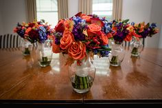 a wooden table topped with vases filled with flowers on top of it's sides