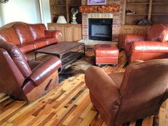 a living room filled with brown furniture and a fire place in the middle of it