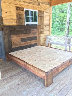 a bed sitting on top of a wooden floor next to a wall covered in wood planks