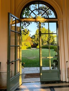 an open door leading into a lush green yard