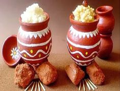 two clay pots filled with food on top of a table