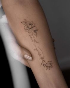 a woman's arm with a flower tattoo on it