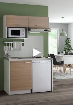 a modern kitchen with green walls and white appliances on the counter top, next to a dining room table