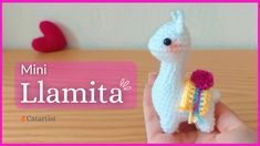 a small white llama holding a flower in it's hand