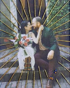 a man and woman are kissing on the steps with flowers in front of their faces