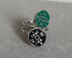 two rings with electronic components on them sitting on a table next to each other in front of a gray background