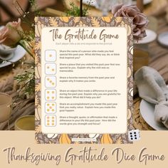 the thanksgiving gratiule dice game is set up on a table with flowers and napkins