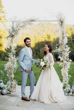 a bride and groom are standing under an arch decorated with flowers in their wedding day