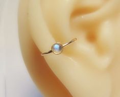 This gold filled moonstone conch hoop is handmade by me using gold filled wire (gold filled wire is different than gold plated in that the plating is much thicker making it higher quality. It will never peel off the way gold plated jewelry does. with proper care it can last as long as real gold.) . a 3mm gold filled setting is soldered onto the ring with a 3mm moonstone set inside of it. You can choose your gauge and diameter at checkout.   *NOTE* To open ring twist to the side to keep its shape Conch Ring, Conch Hoop, Conch Piercing, Plated Jewelry, Open Ring, Jewelry Earrings Hoops, Conch, Gold Plated Jewelry, Real Gold