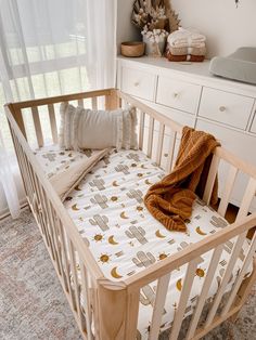 a baby crib with a blanket on top of it