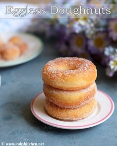 three donuts stacked on top of each other on a plate with flowers in the background