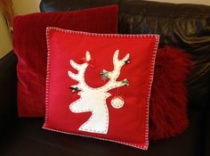 a red pillow sitting on top of a black couch