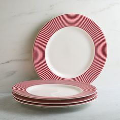 red and white plates stacked on top of each other in front of a marble wall