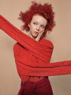 a woman with red hair is posing for the camera