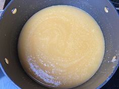 a pan filled with yellow liquid sitting on top of a stove