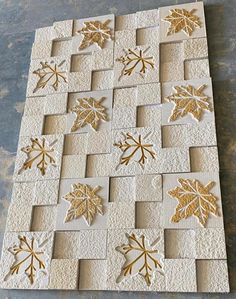 some white and gold paper with leaves on it, sitting on top of a table