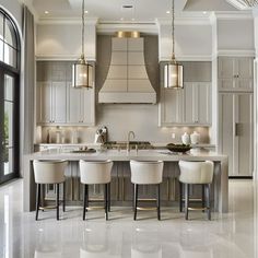 a large kitchen with marble floors and white counter tops, along with four bar stools