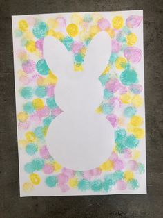 an easter bunny made out of paper with colored dots on the bottom and in the middle