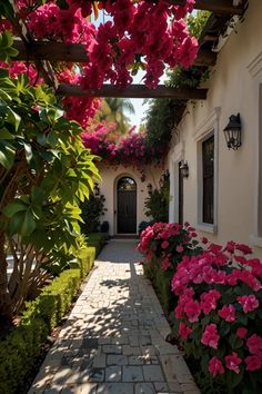 the walkway is lined with pink flowers and greenery