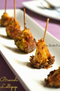 small appetizers are sitting on a plate with toothpicks sticking out of them