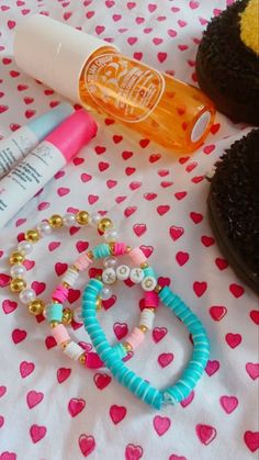 an assortment of items on a table with hearts and polka dot fabric, including bracelets