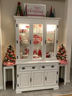 a white china cabinet with christmas decorations on top