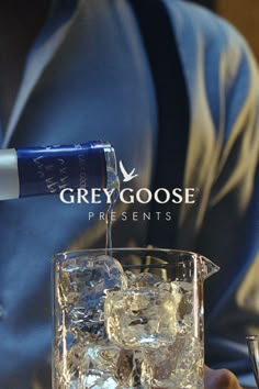 a man pouring vodka into a glass with ice cubes