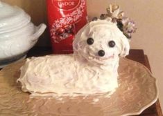 a cake shaped to look like a dog on a plate with flowers in its hair