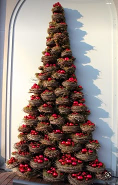 a christmas tree made out of baskets with red balls on it's bottom and sides