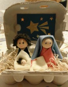 a nativity scene with two dolls in an egg carton