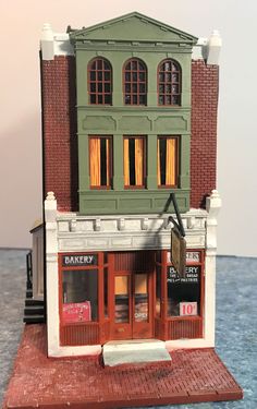 a small toy store with an awning on the front and second story window above it