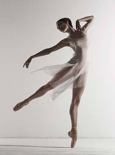 a ballerina is in the air with her arms stretched out and one leg bent