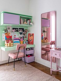 a pink chair sitting in front of a desk with a mirror and toy boxes on it