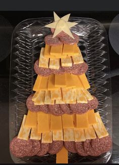 a christmas tree made out of cheese and crackers in a plastic container with a star on top