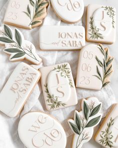 decorated cookies with names and date displayed on white tableclothed surface, top view