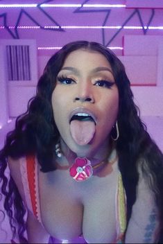 a woman sticking her tongue out in front of the camera and wearing a pink bra