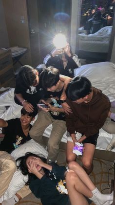 a group of young people sitting on top of a bed next to each other in a room