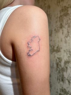 a woman with a small tattoo on her left arm, showing the outline of ireland