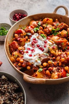 a large pot filled with food next to bowls of vegetables and other foods on a table