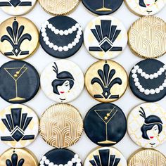 decorated cookies with black, gold and white designs are arranged on a table top in an art deco style