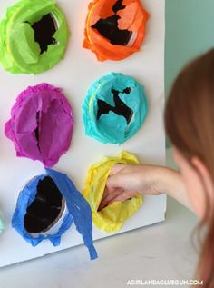 a child is painting different colored paper flowers