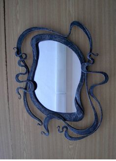 a mirror that is on the side of a wooden door with an octopus like design