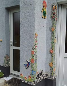 the side of a house with flowers and butterflies painted on it