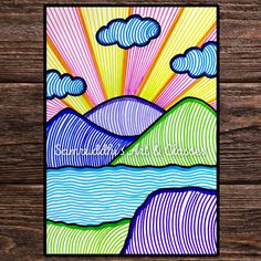 a card with an image of mountains and clouds in the sky, on a wooden background